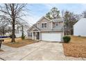 Two-story house with beige siding, a two-car garage, and a driveway at 5480 Sable Bay Pt, Atlanta, GA 30349