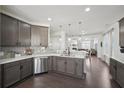 Modern kitchen featuring stainless steel appliances, gray cabinets, and a seamless flow to the living area at 5534 Radford Loop, Fairburn, GA 30213