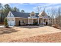 Two-story home with stone and shingle exterior, three-car garage, and expansive yard at 116 Bridle Ridge Ln, Canton, GA 30114