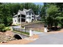 House with a bridge and driveway, surrounded by lush greenery at 3244 Stillhouse Rd, Atlanta, GA 30339