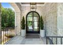 Elegant entryway with arched, black framed double doors and stonework at 3244 Stillhouse Rd, Atlanta, GA 30339