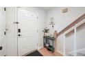Bright entryway with white door, green accent table, and staircase at 6412 Wedgeview Dr, Tucker, GA 30084