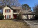 Two-story house with red accents, attached two-car garage, and a well-maintained lawn at 1402 Chelsea Downs Ne Ln, Conyers, GA 30013