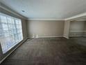 Spacious living room with large window and neutral carpeting at 1402 Chelsea Downs Ne Ln, Conyers, GA 30013