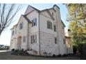 Two-story house with gray brick and white siding, gray shutters, and a three-car garage at 217 Wakehurst Way, Marietta, GA 30064