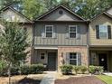 Two-story townhome with gray siding, brick accents, and a landscaped front yard at 4193 Shoals Ln, Union City, GA 30291