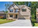 Charming two-story home features a brick facade, a spacious driveway, and a well-manicured lawn at 741 Cams Crk, Mcdonough, GA 30253