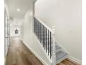 Bright hallway featuring wood floors, white walls, and a staircase with black railings at 3605 Brycewood Dr, Decatur, GA 30034