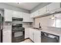 White cabinets, granite countertops, and black appliances at 6622 Wellington Sq, Norcross, GA 30093
