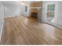 Light filled living room with brick fireplace, wood flooring, and neutral color palette at 2082 Rainbow Dr, Snellville, GA 30039