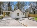 White house with carport, landscaping, and wooden fence at 1685 Harbin Sw Rd, Atlanta, GA 30311