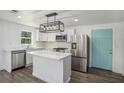 Modern kitchen with white cabinets, island, stainless steel appliances, and hardwood floors at 1685 Harbin Sw Rd, Atlanta, GA 30311