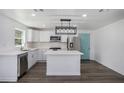 Modern kitchen with white cabinets, island, stainless steel appliances, and hardwood floors at 1685 Harbin Sw Rd, Atlanta, GA 30311