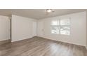 Bright living room featuring gray vinyl flooring and a large window at 1203 Sandune Dr, Norcross, GA 30093