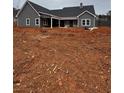 Rear view of gray farmhouse, unfinished landscaping at 1330 Temple Draketown Rd, Temple, GA 30179