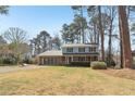 A quaint two-story home with blue siding, a brick facade, and a lush green front yard at 201 Nouveau Sw Ct, Lilburn, GA 30047