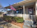 Ranch home with covered porch, American flag, and landscaping at 1349 Highway 81 E, Mcdonough, GA 30252