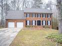 Two-story brick home with a two-car garage and manicured lawn at 1853 Edington Sw Rd, Marietta, GA 30064