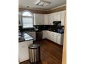 Kitchen with white cabinets, granite countertops, and hardwood floors at 2080 Milfield Cir, Snellville, GA 30078