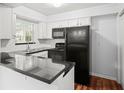 Modern kitchen with black appliances and granite countertops at 6940 Roswell Rd # 24E, Sandy Springs, GA 30328