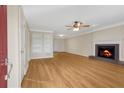 Inviting living room featuring a cozy fireplace, ceiling fan, and light wood flooring at 1094 Old Roswell Rd, Roswell, GA 30076