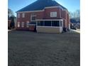 Rear view of house showing screened porch and yard at 240 Flowers Cove Ln, Lilburn, GA 30047