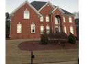 Brick house with a two-car garage and manicured lawn at 240 Flowers Cove Ln, Lilburn, GA 30047