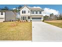 A charming two-story house with a clean front lawn, long driveway and a two-car garage at 7293 Eton Ln, Locust Grove, GA 30248