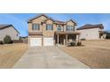 Two-story house with a three-car garage and a covered porch at 7705 Sylvaner Ln, Atlanta, GA 30349