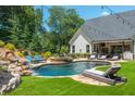 Luxury pool with waterfall feature and lounge chairs at 201 Edwards Brook Ct, Canton, GA 30115