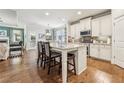 Open kitchen boasts a center island with bar seating, granite countertops, stainless appliances, and hardwood floors at 2090 Red Barn Ct, Cumming, GA 30040