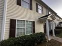 Tan siding townhouse with brown shutters and a covered entryway at 990 Harbins Rd # 5D, Norcross, GA 30093