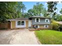 Ranch style home with gray and yellow siding, landscaped lawn, and driveway at 2666 Frontier Trl, Atlanta, GA 30341