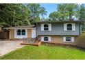 Ranch style home with gray and yellow siding, landscaped lawn, and driveway at 2666 Frontier Trl, Atlanta, GA 30341