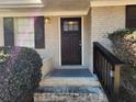 Brick front porch with dark brown door and black railing at 4427 Sun Valley Blvd, Atlanta, GA 30344