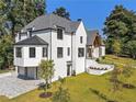 White house with gray roof, landscaping, and a paved driveway at 464 Pine Tree Ne Dr, Atlanta, GA 30305