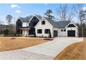 Two-story farmhouse with white and black exterior, a large driveway, and landscaping at 208 Pindos Sw Pl, Powder Springs, GA 30127