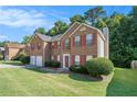 Brick two-story home with a two-car garage and manicured lawn at 1246 Carriage Trace Cir, Stone Mountain, GA 30087