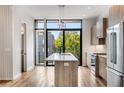 Modern kitchen featuring wood cabinets, stainless steel appliances, quartz countertop, island, and large window at 105 Georgia Se Ave # 1, Atlanta, GA 30312