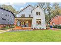 Two-story modern farmhouse with gray and white siding, a covered porch, and landscaped yard at 1356 Deerwood Dr, Decatur, GA 30030