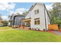 Two-story modern farmhouse with gray and white siding, a covered porch, and landscaped yard at 1356 Deerwood Dr, Decatur, GA 30030