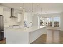 Modern kitchen with white cabinets, stainless steel appliances, and large island with pendant lighting at 4382 Benfield Se Way, Smyrna, GA 30080