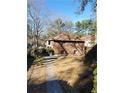 Brick home's side view, showcasing a sizable yard and walkway at 141 Holly Nw Rd, Atlanta, GA 30314