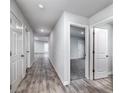 Bright hallway with wood-look flooring and doors to bedrooms at 2058 Dickons Garden Ln, Mcdonough, GA 30253