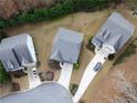 An aerial view of three homes showcasing driveway, professional landscaping, and mature trees on a cul-de-sac at 1055 Grove Valley Dr, Cumming, GA 30041