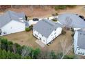 Rear exterior view of a two-story white home featuring a basketball court on a flat lot at 1055 Grove Valley Dr, Cumming, GA 30041