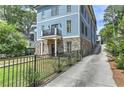 Three-story home with stone and blue siding, a driveway, and a landscaped front yard at 2972 Lookout Ne Pl, Atlanta, GA 30305