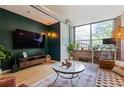 Open living area with hardwood floors, exposed brick and a large TV at 800 Peachtree Ne St # 8429, Atlanta, GA 30308