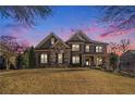 Stunning brick home exterior at dusk with beautiful landscaping at 2082 Greenway Mill Ct, Snellville, GA 30078