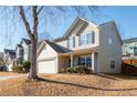 Two-story house with beige siding, a white garage door, and a landscaped yard at 311 Tuggle Ct, Woodstock, GA 30188